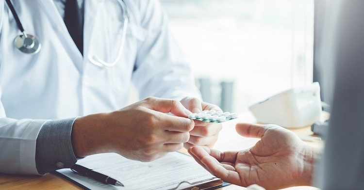 Doctor or physician recommend pills medical prescription to male Patient